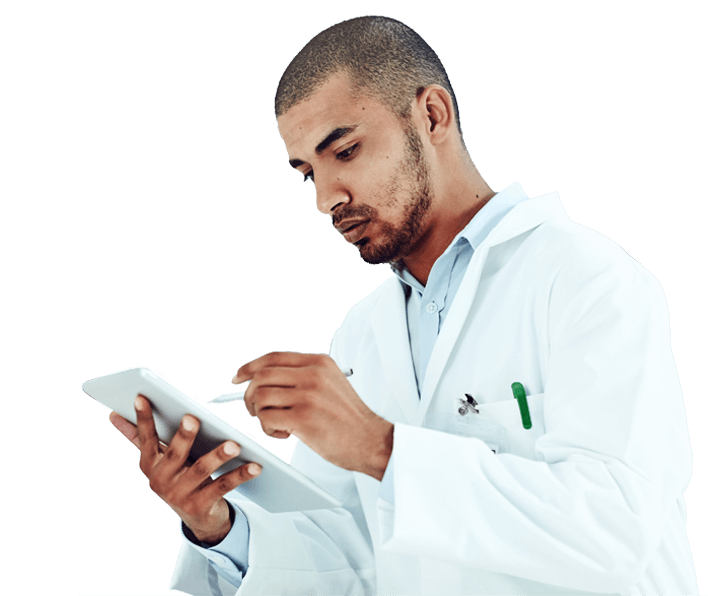 A person in a lab coat looks at a tablet