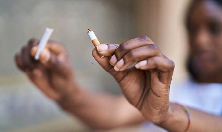 a person breaking a cigarette in half