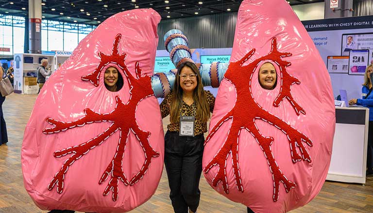 An attendee posing with people in lung costumes