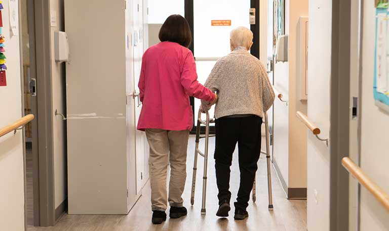 Chinese American Service League employee walks with resident from the community