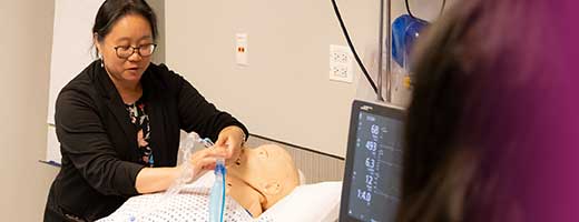 a faculty member demonstrates mechanical ventilation during a simulation course