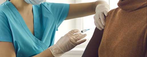 A health care provider gives an injection to a patient