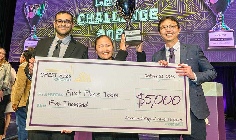 Three CHEST Challenge winners smile with a check and trophy