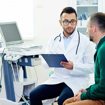 A person in a white lab coat talks to a patient