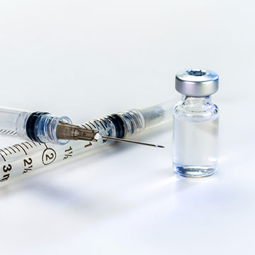 A vile of liquid and hypodermic needles